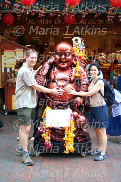 SINGAPORE - Stroking Buddah's belly for good luck / Tocándole la barriguita a Buddah para que nos traiga suerte