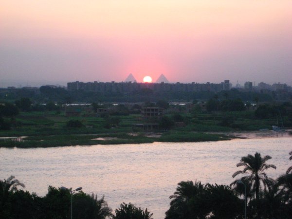 Best sunset spot EVER!  The sun sets right between two pyramids and the Nile in the foreground!
