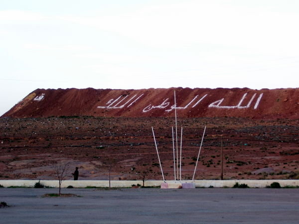 "Allah is King" in arabic on a dirt hill