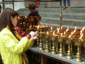 Lighting lamps at the Buddhist temple at Leshan