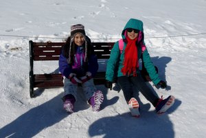 Cute girls on the snowed in bench