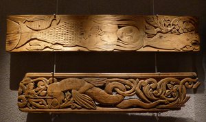 Two carved boards: Top - mermaid has captured a man; Bottom - man fighting a dragon