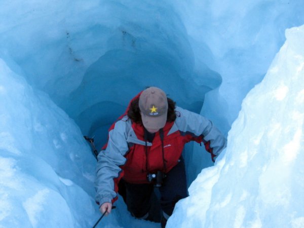 Dee climbing through an ice tunnel