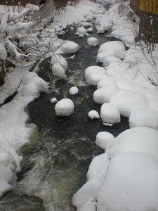 snow covered rocks in the stream
