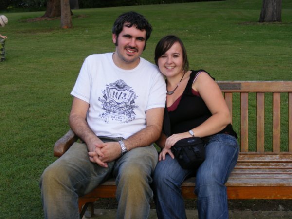 Gary and Emma on a bench in the park, smiling