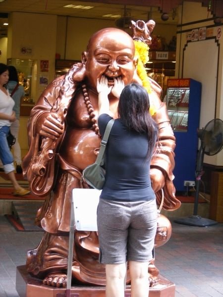Poeple praying and touching the Buddha for good luck