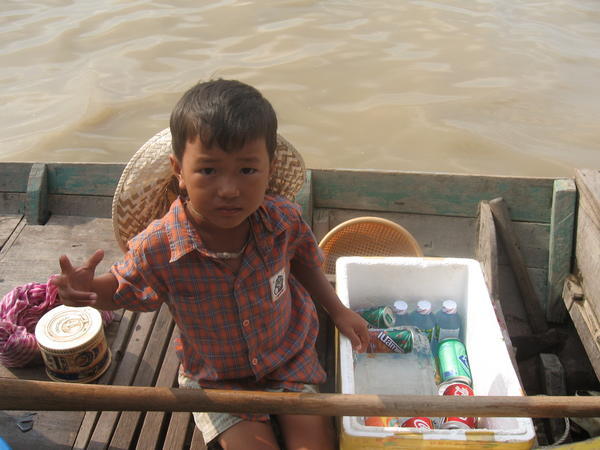 Petit garçon qui vend des choses aux touristes en bateaux