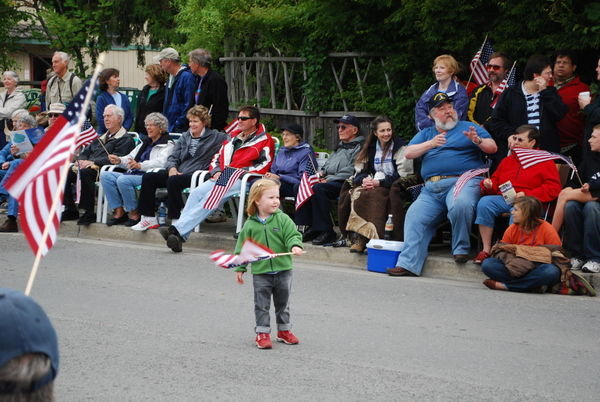 Patriotic toddler waving her flag at the parade