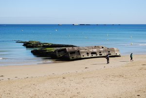 People inspecting the remants left from Mulberry Harbour at Arromanches