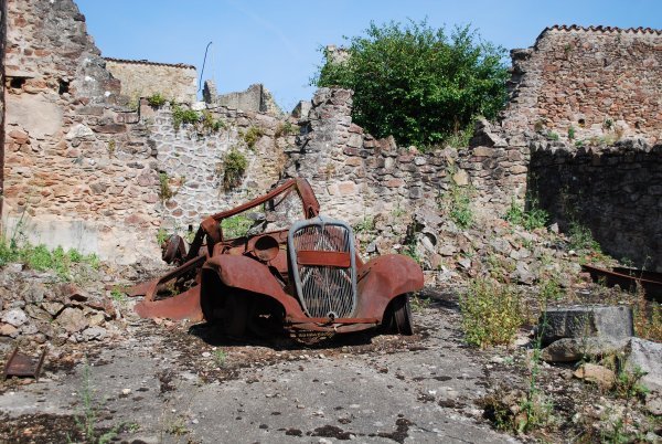 Rusted car sitting in a garage at Oradour-sur-Glane