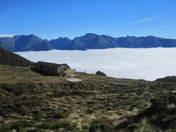 Luxmore Hut above the clouds in the morning sun