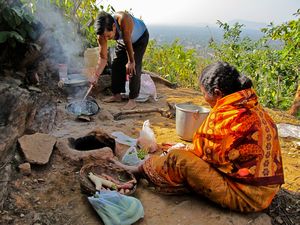 Old couple cooking at the top of a hill