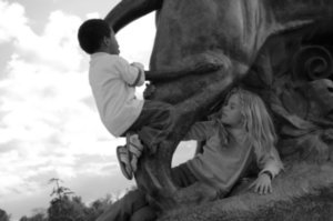 kids playing on one of the giant lions by the lake