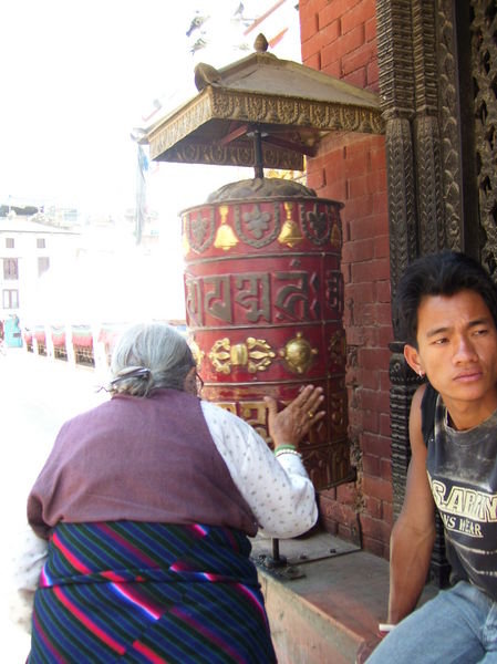 A tibetan grandma spinning the prayer wheel