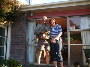 Owen, Shelly, and the furry Seymor in front of their lovely home