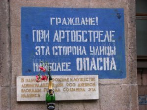 Sign requesting pedestrians to use the other side of the road during artillery attack