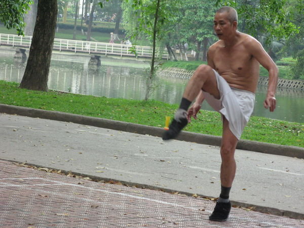 Sporty old man, playing a sort of badminton with feet