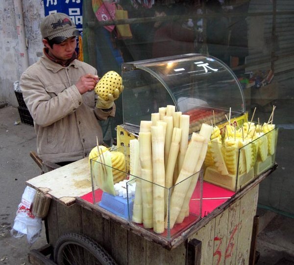 Fresh pineapple on a stick and peeled sugarcane is available everywhere