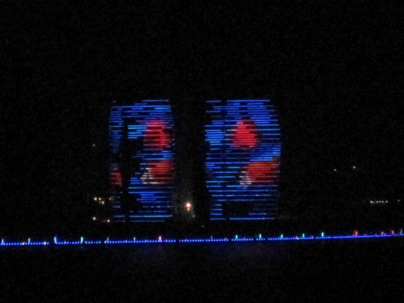 The sides of these huge resort buildings become video screens at night.
