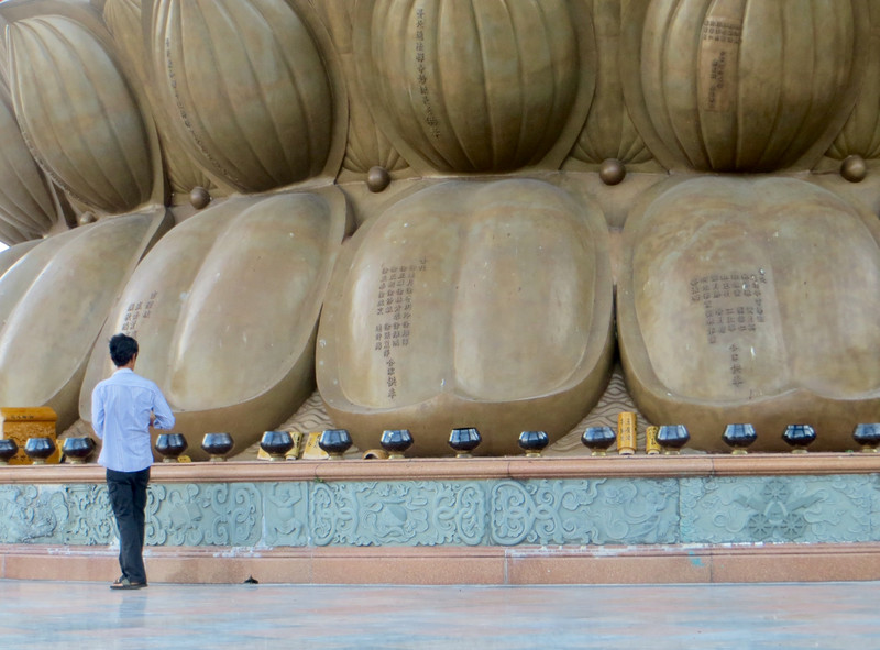 Placing coins in prayer bowls at the base of Goddess of Mercy, Kuan Yin at Kek Lok Si Temple