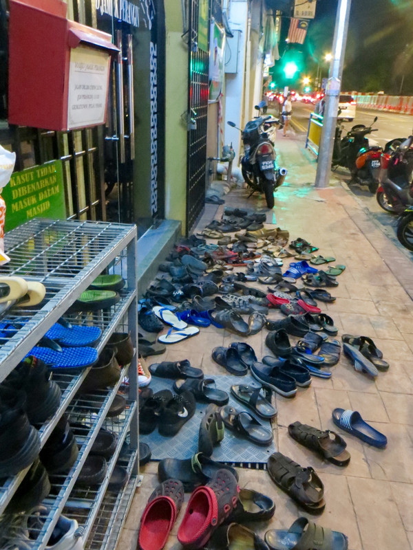 Shoes on the footpath out side tiny shop front mosque