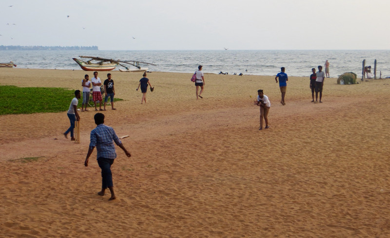 A boisterous games of cricket on the beach at sunset in Negombo
