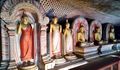 Row of Buddhas and wall art within main Dambulla temple