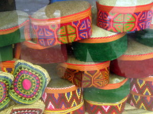 Display of embroidered caps in shop window, Kaza