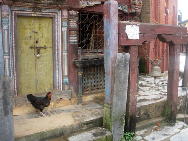 Temple door, bell and hen , main street Bandipur