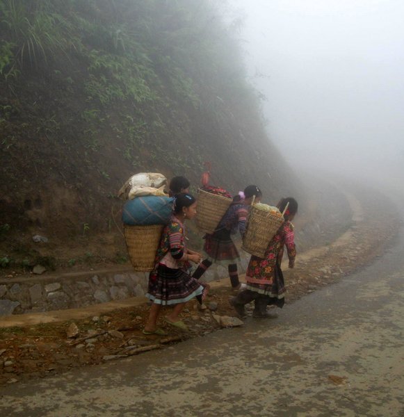 Young girls walking through the fog home after the market