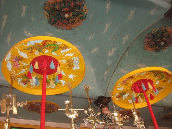 Umbrellas over altar and ceiling decoration at Cao Dai temple