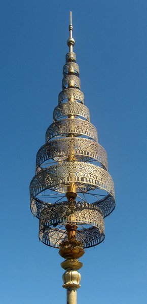 A brass umbrella style pagoda top which is a traditional roof decoration 