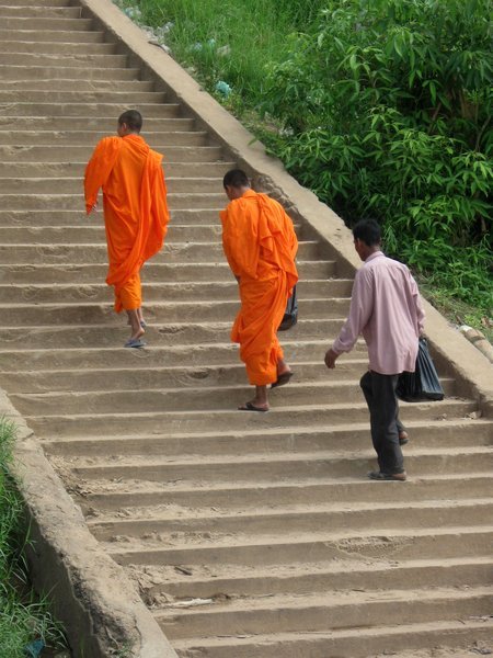 Monks climbing up from the riverbank 