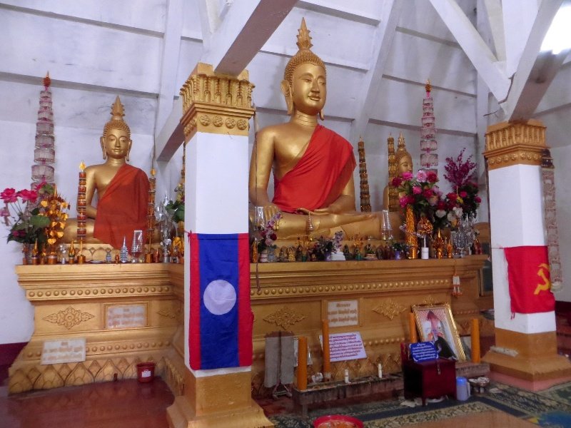 Buddha statues and flags inside the Wat.