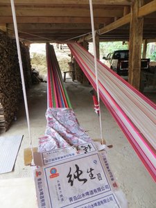 Long weaving frame under house in Baka