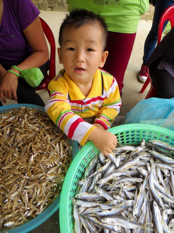 Young boy playing with the dried fish at the village where we ate lunch on our day out on the lake