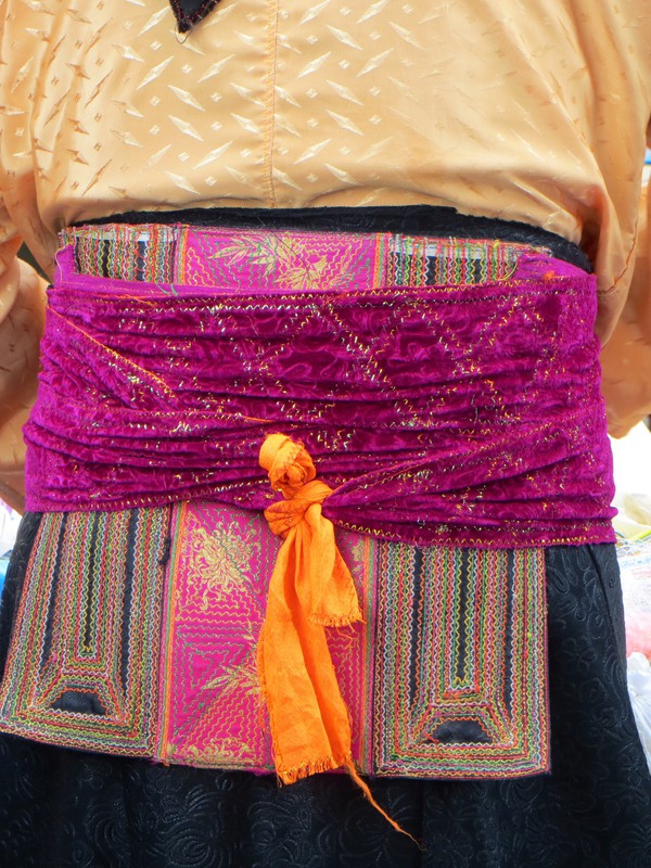 The embroidered square which the ladies tie around their waist over which they tie a wide cummerband style belt