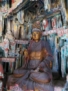 Very dusty golden wooden Buddha in one of Hanging Monastery small internal temple rooms