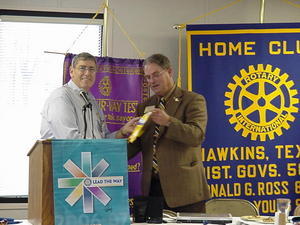 Hawkins Rotary President Bob Schneider presents banner to PDG Kent Converse, Larned Rotary