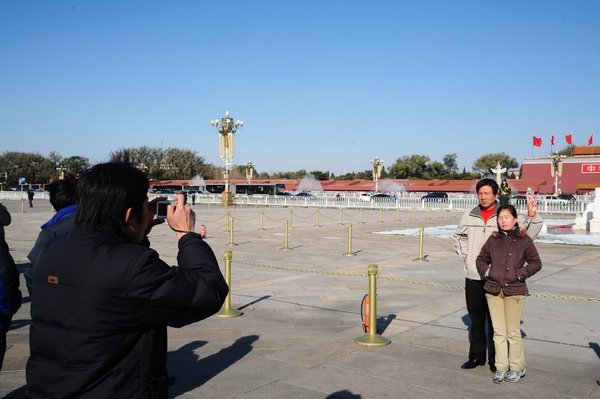 Migrant tourists have their photos taken in Tianmen Square
