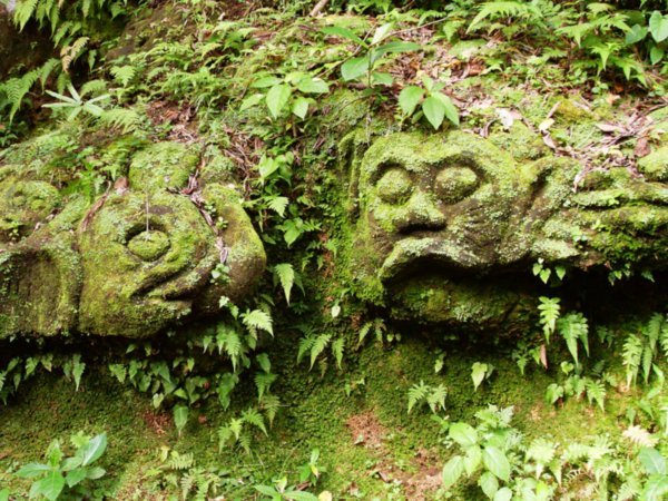 Old faces on the rocks at Goa Gajah
