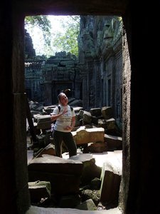 Janine trying to duplicate a pose depicted on the wall at Ta Phrom