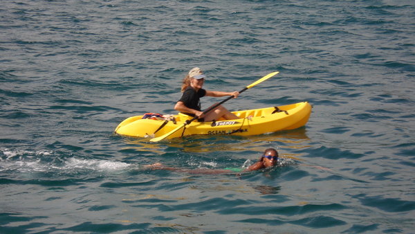 Swimming racer accompanied by kayak