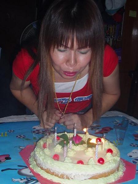 Pee Nong blowing out her candles.