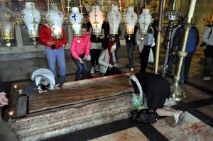 Orthodox Russians kneeling in front of the Stone of Unction