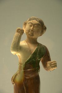 Polychrome-glazed pottery figurine of man leading a camel