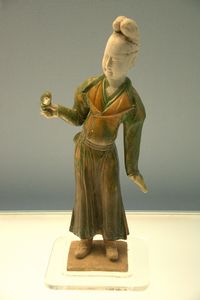 Polychrome-glazed pottery figurine of woman with a parrot in her hand