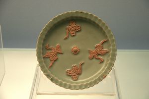 Celadon dish with applied cloud and phoenix design on exposed body