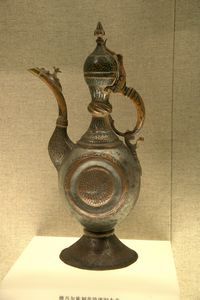 Copper pitcher with a carved motif and a laquered inlay