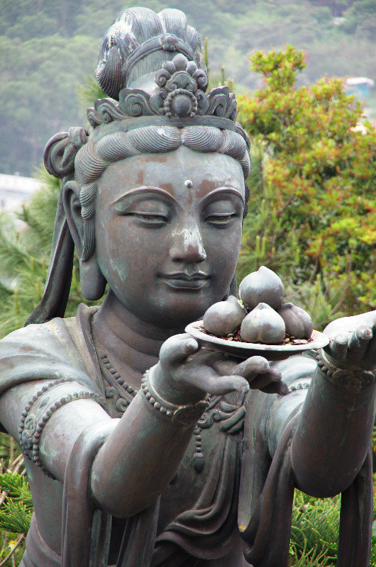 Female Buddhist statue making offerings to Buddha